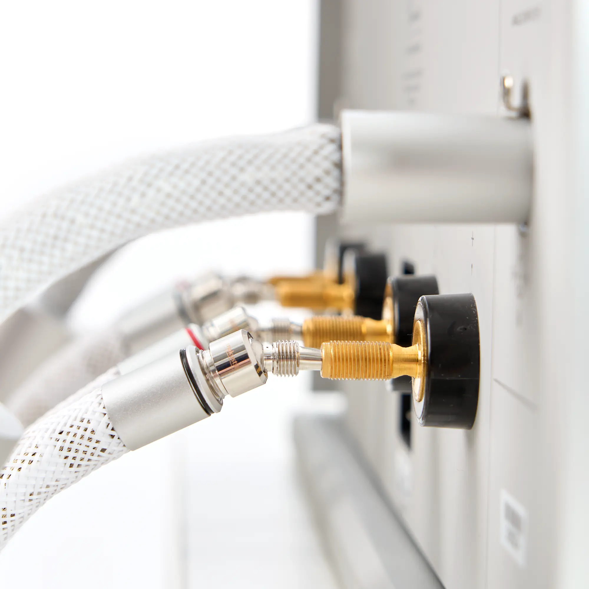 Close-up of an LS-8005 speaker cable with silver and gold-colored connectors attached to a device 