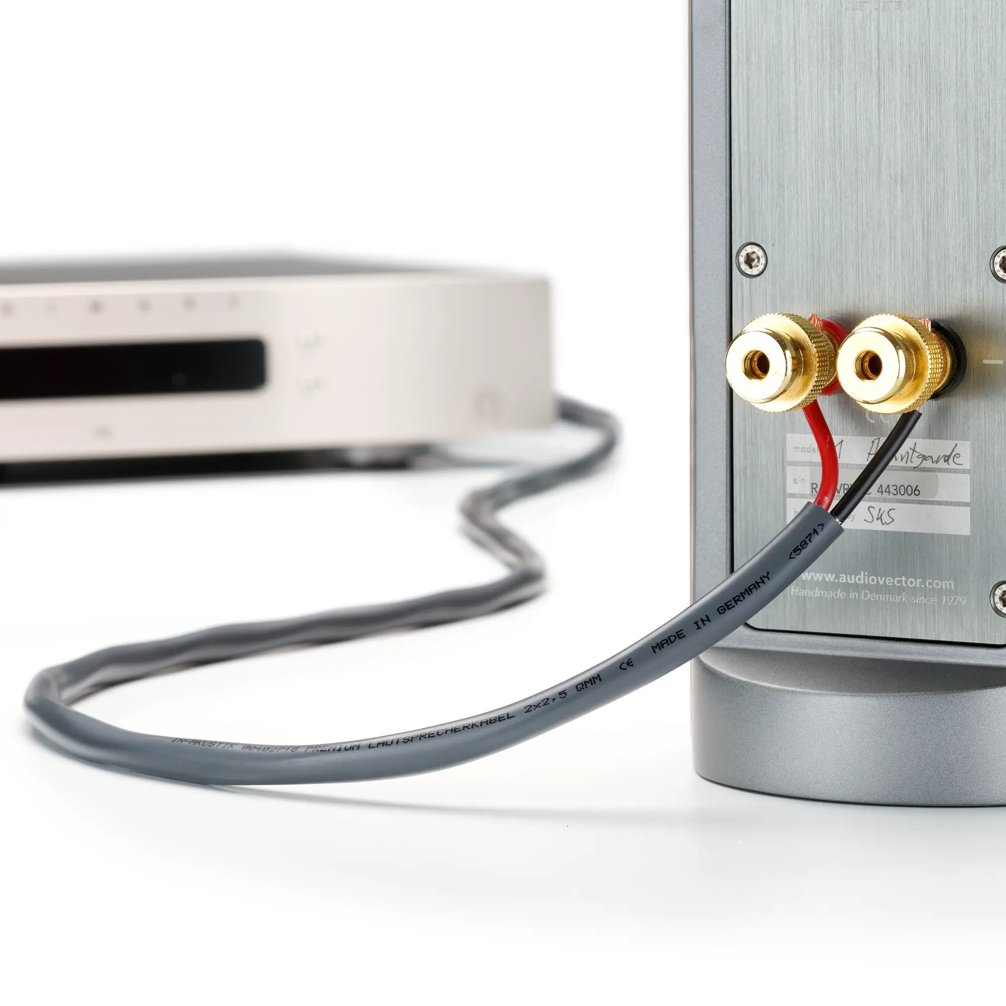 Product image of the flame-retardant premium speaker cable connected to a speaker and amplifier.