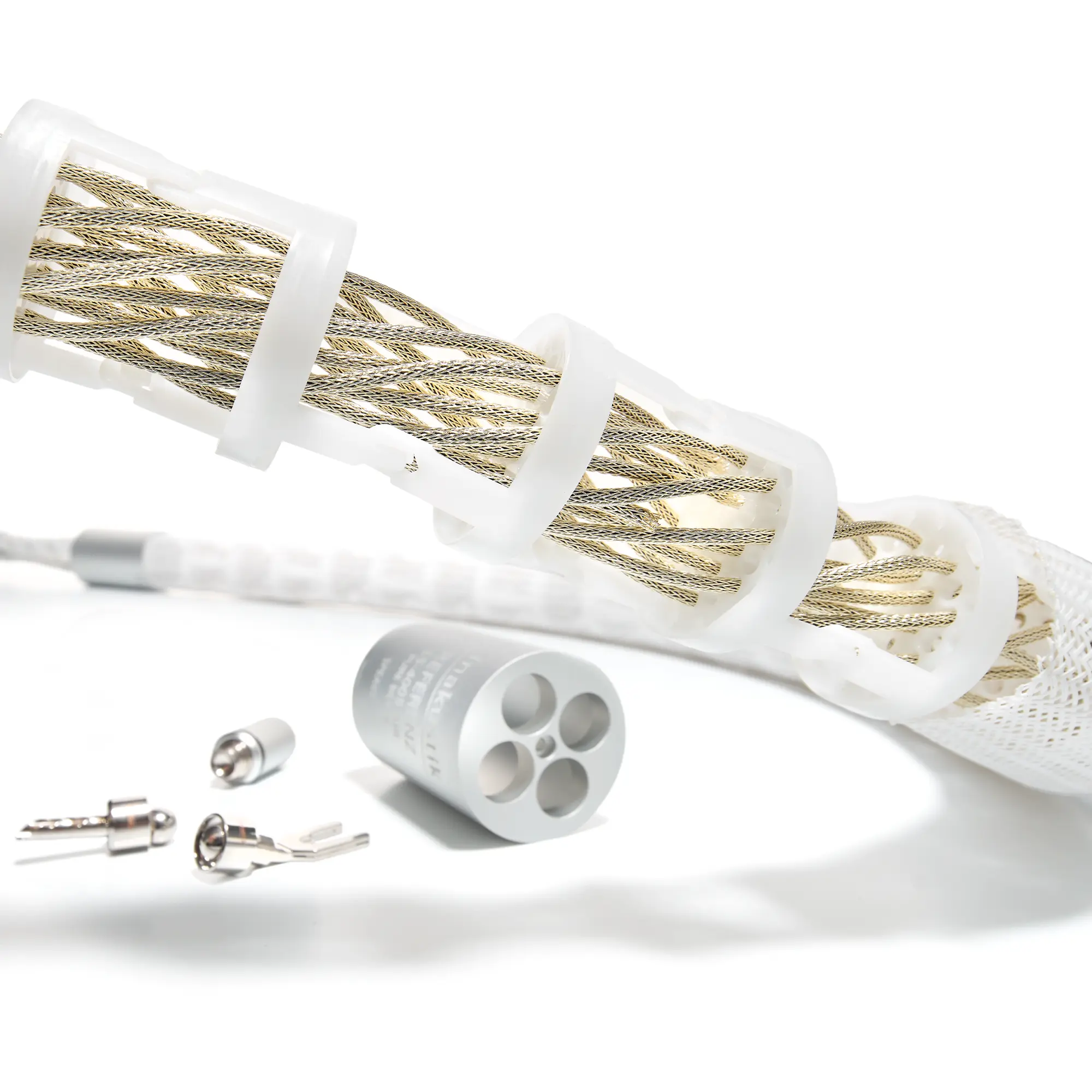 Close-up of the interior of a speaker cable featuring braided silver wires, white plastic clips, and several silver connectors 